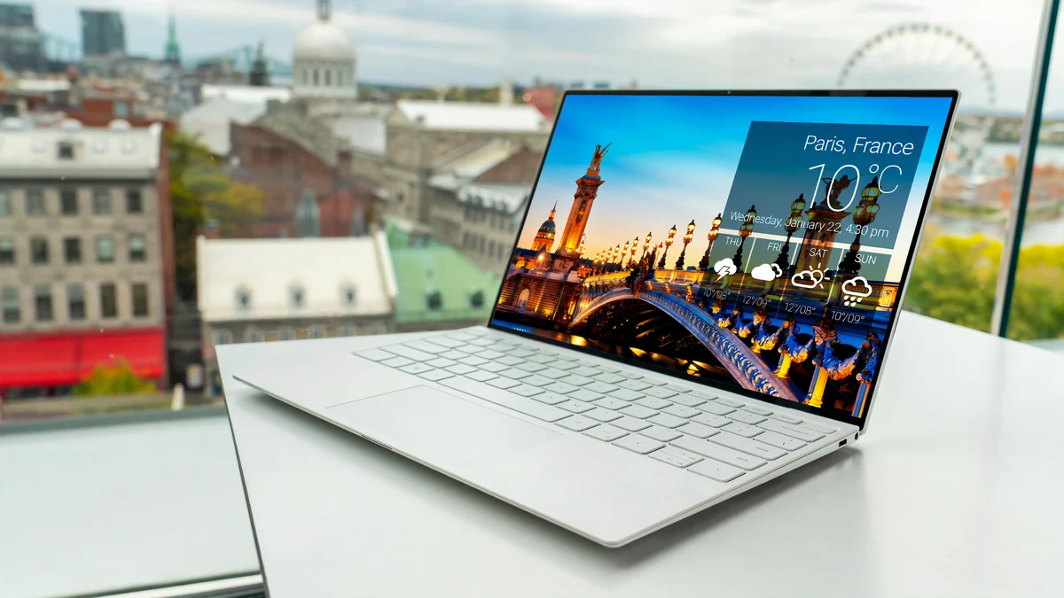 An open Dell laptop on a white desk.